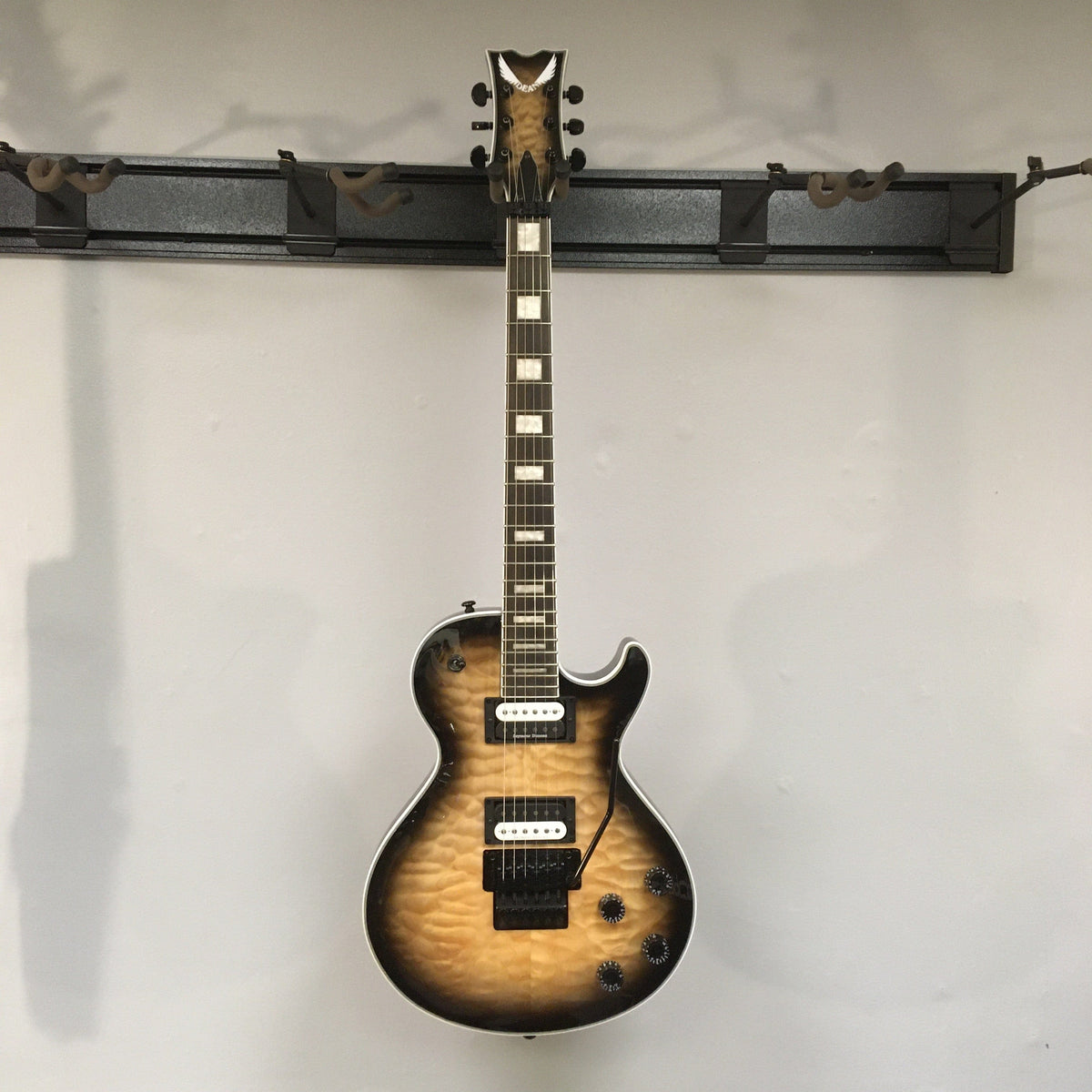 Dean Thoroughbred Select Quilt-top guitar with Floyd Rose bridge, Seymour Duncan pickups, and satin-finished neck on a stand.