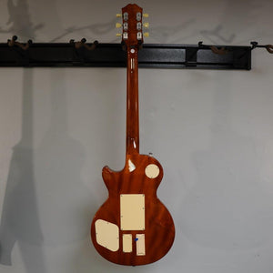 Epiphone Alex Lifeson Les Paul Axcess Standard - Viceroy Brown guitar displayed on a wall, showcasing its craftsmanship and design.