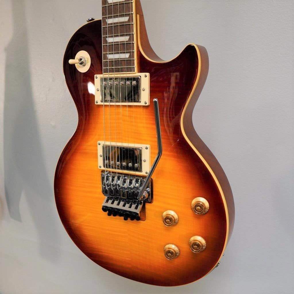Epiphone Alex Lifeson Les Paul Axcess Standard - Viceroy Brown, featuring a carved maple top, humbucker pickups, and a Floyd Rose tremolo, mounted on a wall.