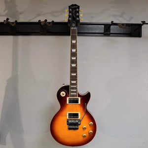 Epiphone Alex Lifeson Les Paul Axcess Standard guitar displayed on a wall, showcasing its classic Les Paul shape and detailed craftsmanship.