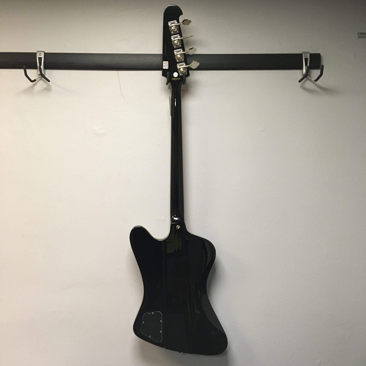 Epiphone Thunderbird Vintage PRO Bass Black, displayed on a wall, showcasing its sleek design and iconic 1960s style.