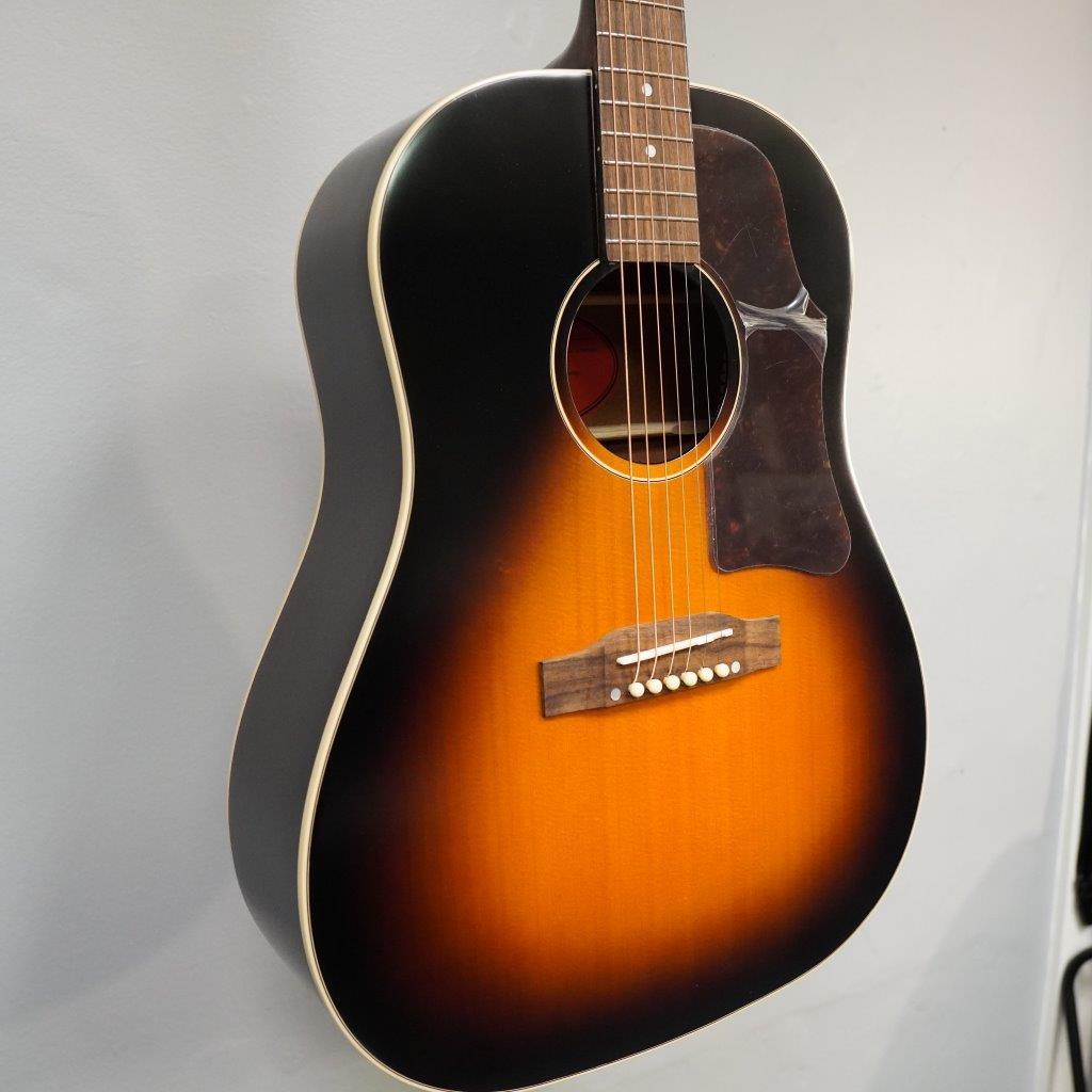 Epiphone Masterbilt J-45 acoustic guitar, Aged Vintage Sunburst Gloss, displayed close-up, showcasing its solid wood construction and distinctive 60s Kalamazoo headstock.