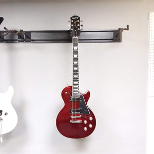Epiphone Les Paul Modern electric guitar, featuring a sleek design with asymmetrical neck and modern contoured heel, displayed on a wall.