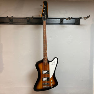 Epiphone Thunderbird IV bass guitar with reverse headstock hanging on a wall.