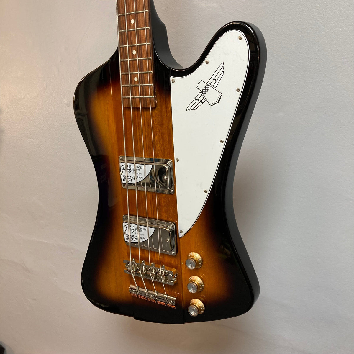 Epiphone Thunderbird IV Reverse Headstock Vintage Sunburst electric bass guitar, close-up of body, dials, and neck. Iconic rock and roll design, in stock.