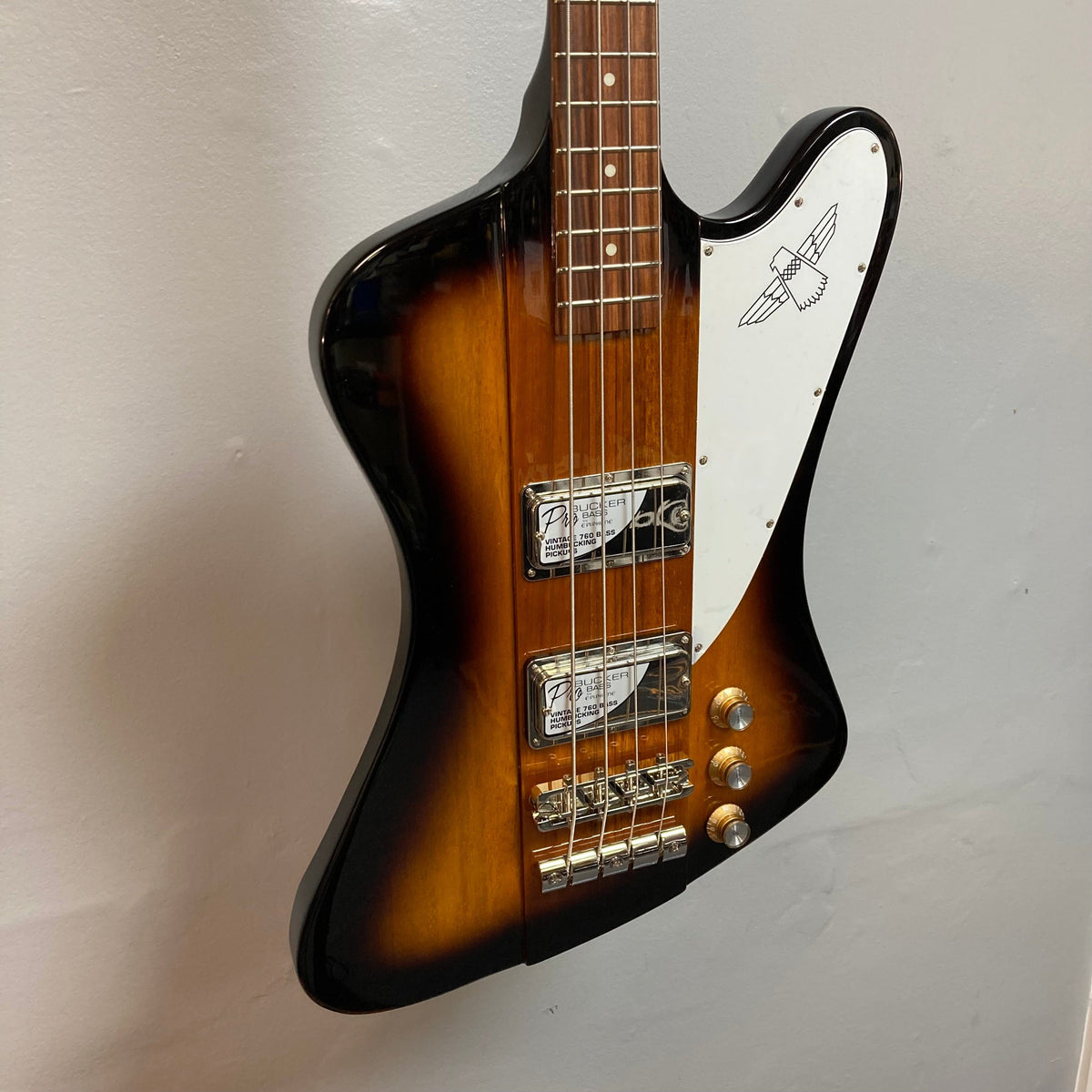 Epiphone Thunderbird IV Reverse Headstock Vintage Sunburst bass guitar with distinctive zig-zag body design and close-up details of pickups and strings.