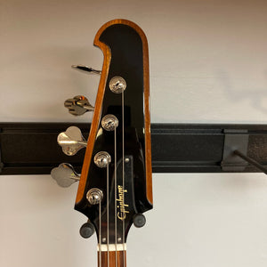 Epiphone Thunderbird IV bass guitar on a stand, featuring its iconic reversed body and headstock design.