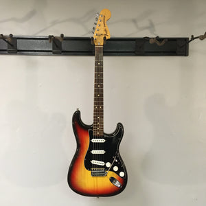 1976 Fender Stratocaster Sunburst, all original, displayed on a wall, with close-ups showing its excellent condition and original parts.