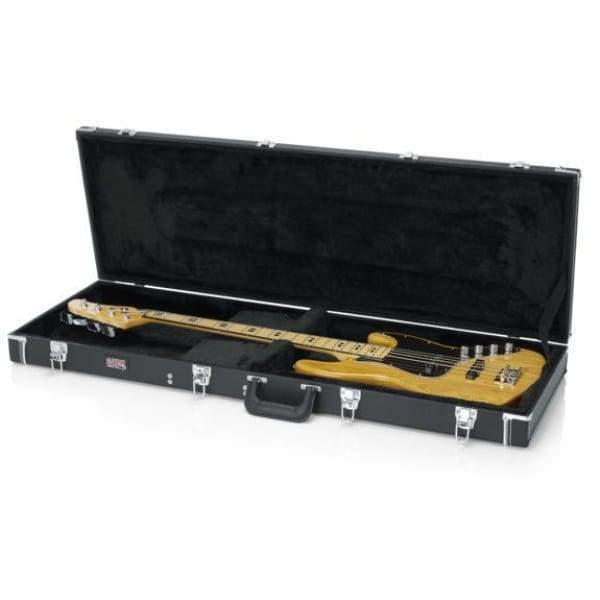 A yellow electric bass guitar rests in the Gator Deluxe Wood Bass Guitar Case by Gator, featuring black fabric lining, silver latches, and a sturdy handle. Both case and guitar are displayed on a white surface.