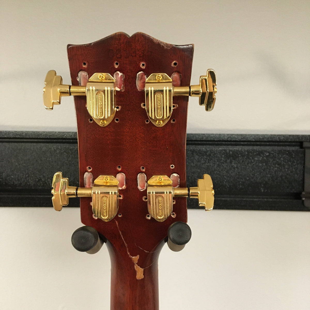 Close-up of a vintage Gibson EB-2C bass guitar, highlighting its worn, modified look and metal components. Available at Guitars on Main.
