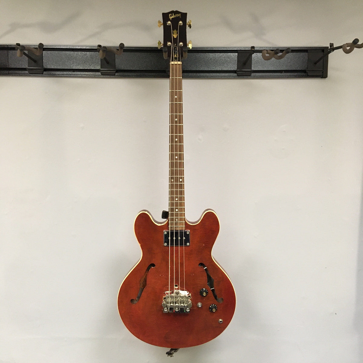 Gibson EB-2C 1958-1965 bass guitar, vintage with modifications, displayed on a wall.