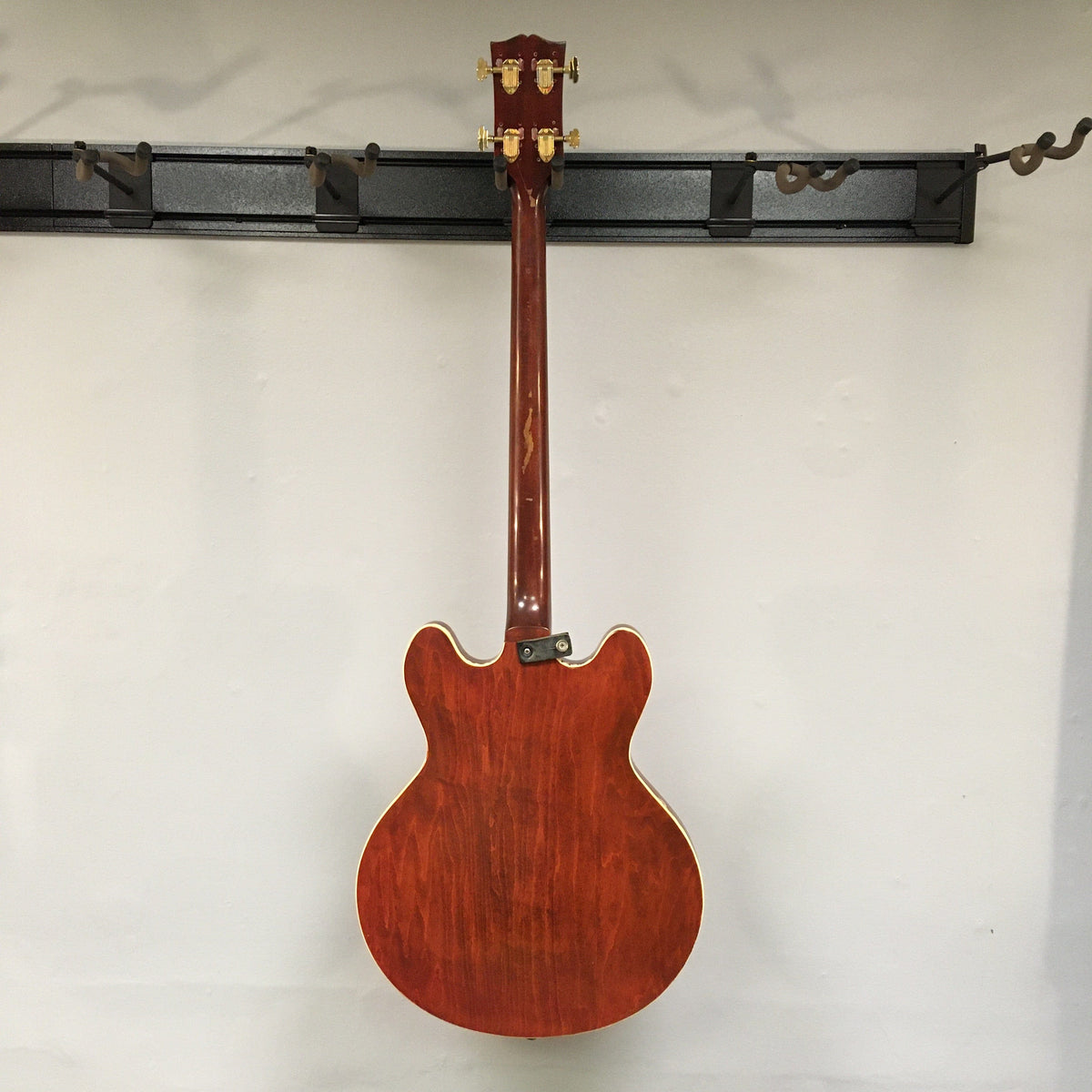 Gibson EB-2C 1958 to 1965? Bass Used hanging on a wall, showcasing its vintage design and modifications.