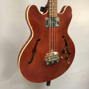 Close-up of a vintage Gibson EB-2C bass guitar, showcasing its strings and neck, highlighting its relic condition and historical significance.