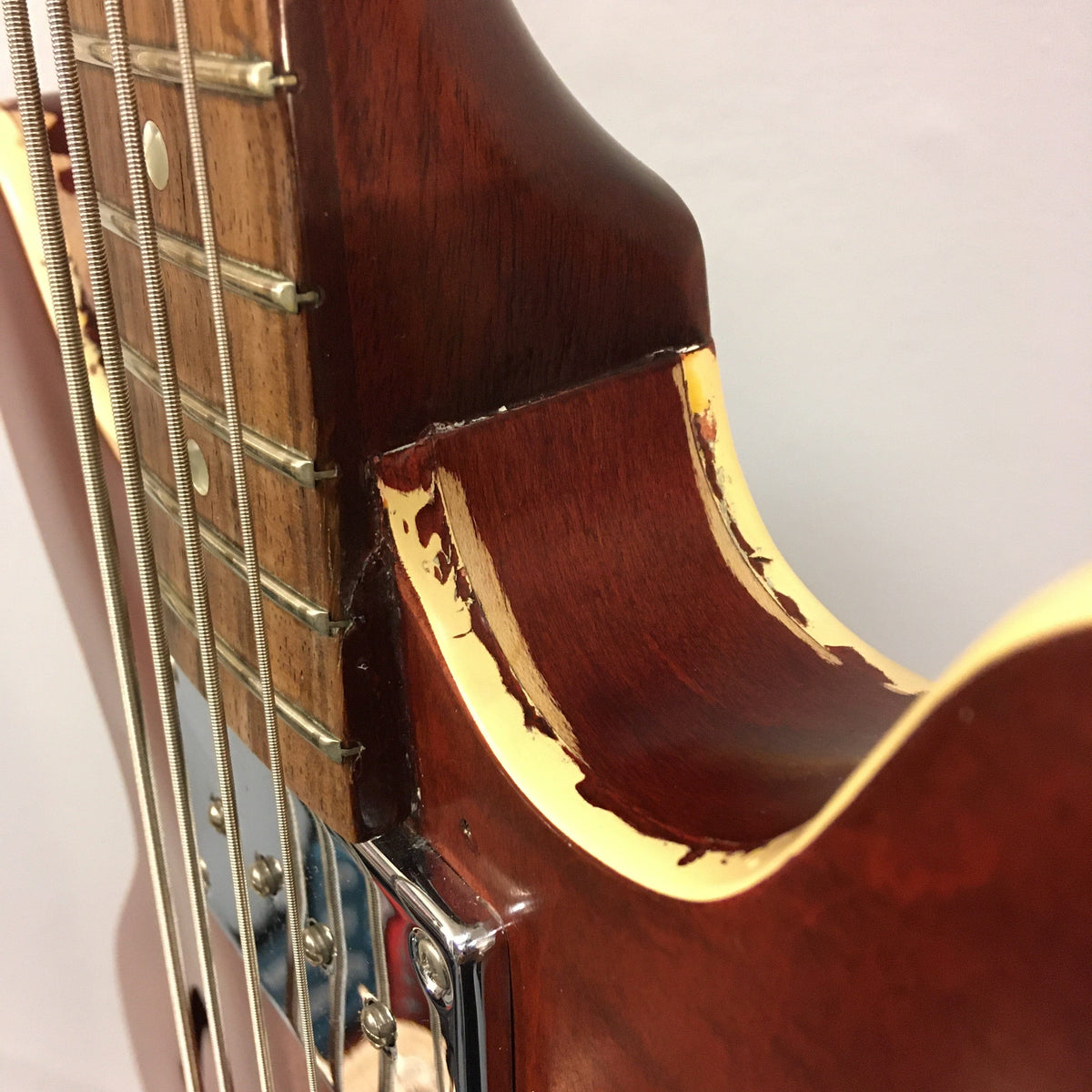 Close-up of the neck and strings of a vintage Gibson EB-2C 1958-1965 Bass, showcasing its relic look and modifications.