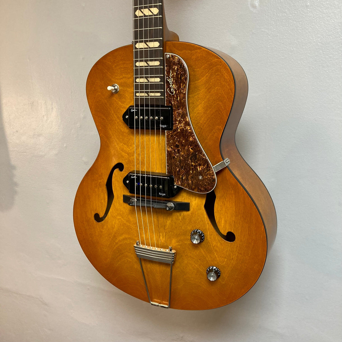 Godin 5th Avenue Jumbo P90 Harvest Gold guitar, featuring a Memphis Sun finish, visible P-90 pickups, redesigned headstock, and large fret markers.