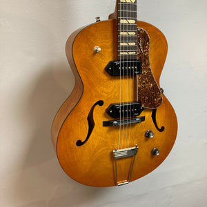 Godin 5th Avenue Jumbo P90 Harvest Gold guitar with redesigned headstock, large fret markers, and Godin logo, showcased for the 50th anniversary.