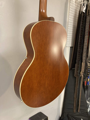 Godin 5th Avenue Kingpin P90 Cognac Burst archtop electric guitar, crafted from Canadian Wild Cherry, leaning against a white wall.