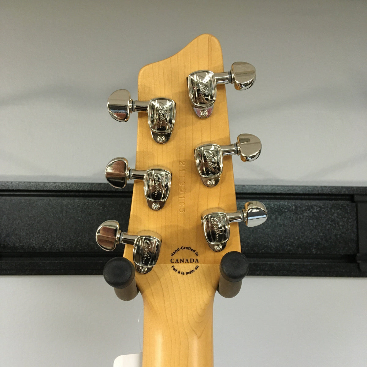 Close-up of the Godin A6 Ultra Baritone guitar head with silver knobs and logo.