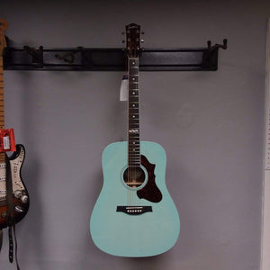 Godin Imperial Laguna Blue GT EQ acoustic guitar with mahogany body, spruce top, and LR Baggs Anthem system, mounted on a wall.