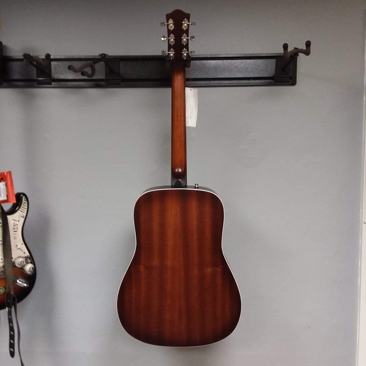 Godin Imperial Laguna Blue GT EQ acoustic guitar with solid mahogany back, Sitka spruce top, and richlite fingerboard, mounted on a wall.