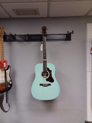 Godin Imperial Laguna Blue GT EQ acoustic guitar with a solid mahogany body, Sitka spruce top, and on-board preamp, displayed against a wall.