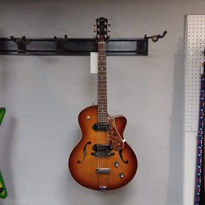 Godin 5th Avenue CW Kingpin II Cognac Burst guitar with P90 pickups, displayed on a wall.