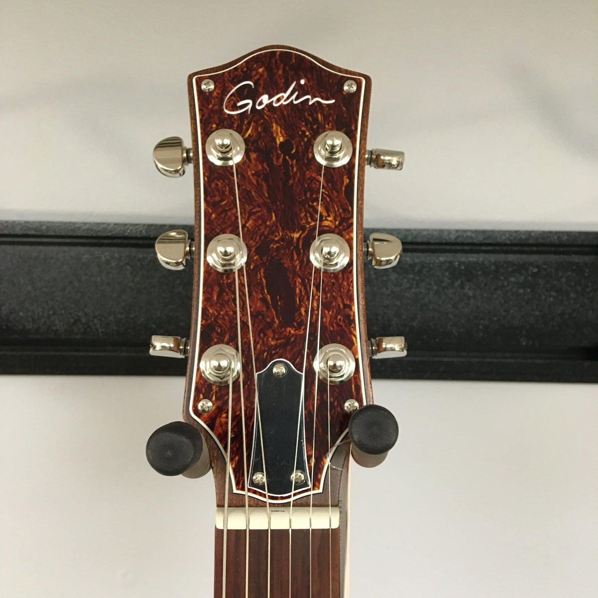 Close-up of the Godin Montreal Premiere HT Trans White guitar, highlighting its mahogany neck, rosewood fingerboard, and hard-tail bridge.