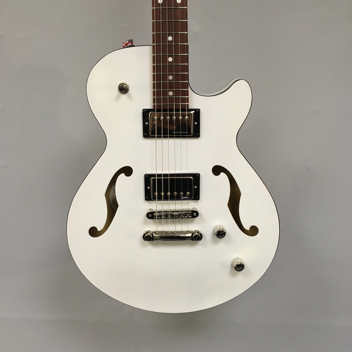 Godin Montreal Premiere HT Trans White guitar with white body, brown strings, black accents, and a Hard-tail bridge.
