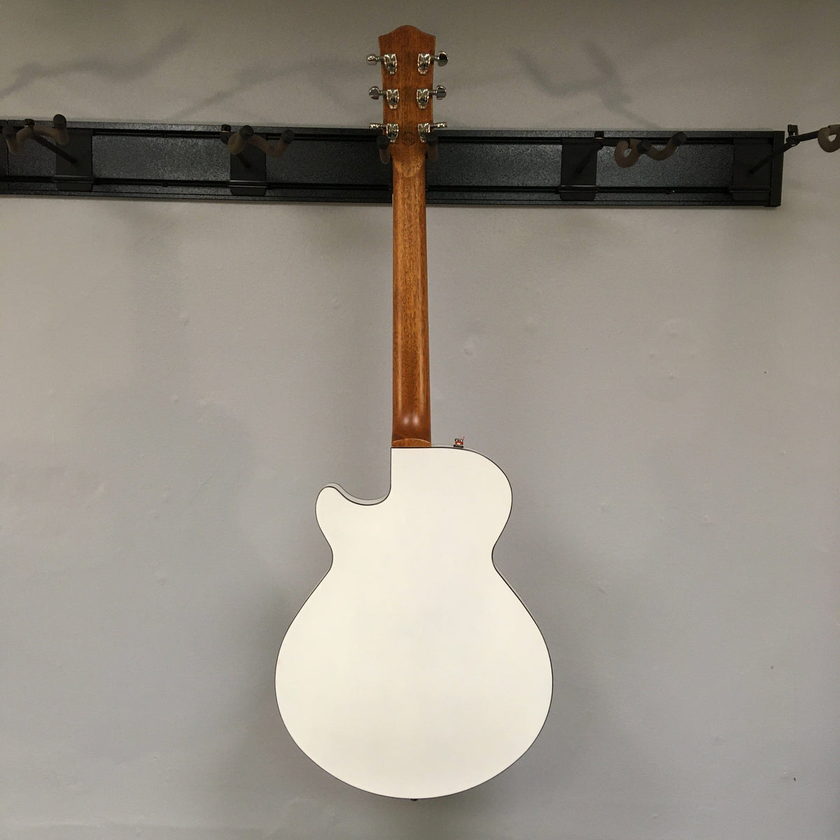 Godin Montreal Premiere HT Trans White Open Box guitar displayed on a wall, featuring a semi-gloss finish and hard-tail bridge.