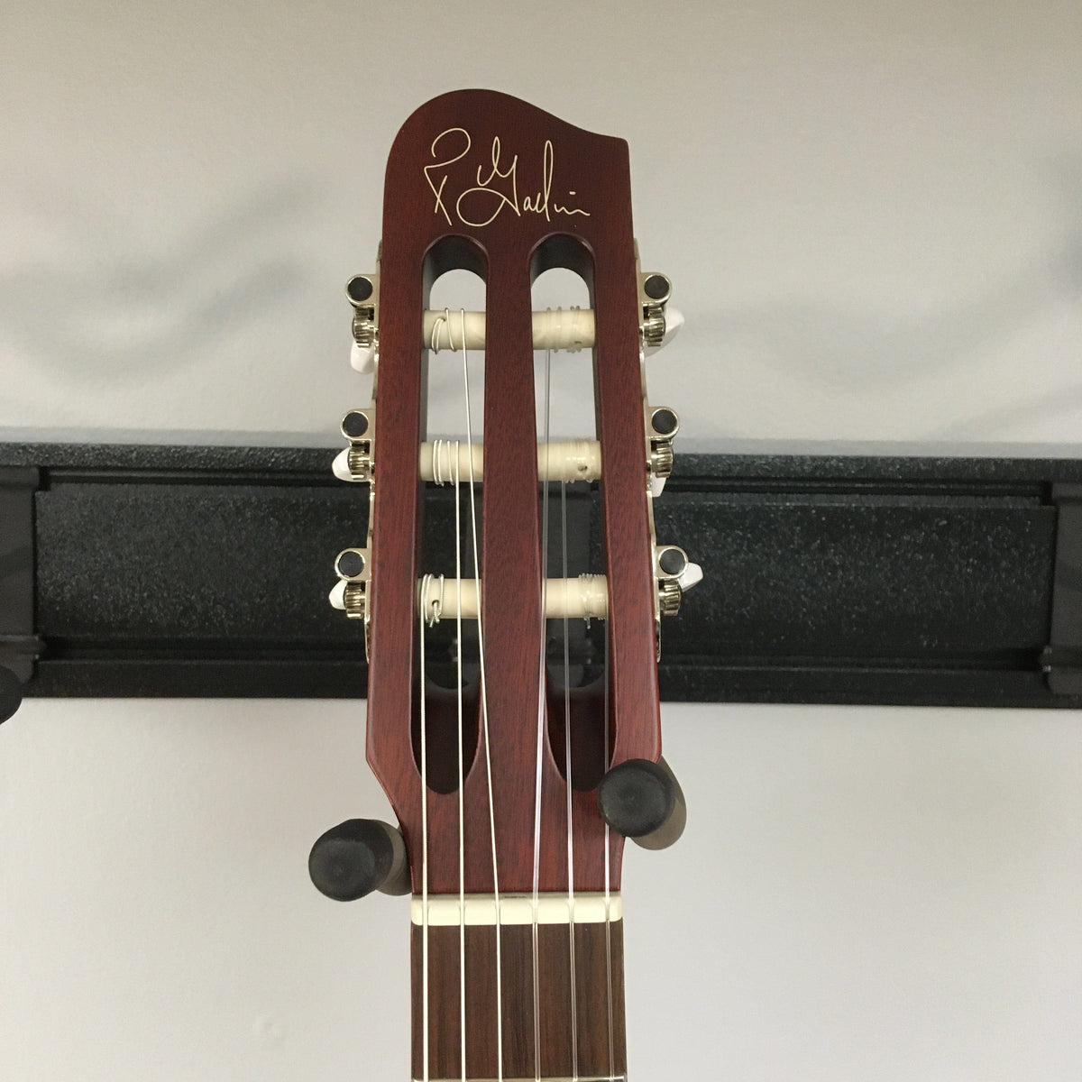 Close-up of the Godin Multiac Nylon Encore SG SF guitar headstock, showing tuning pegs and part of the neck.
