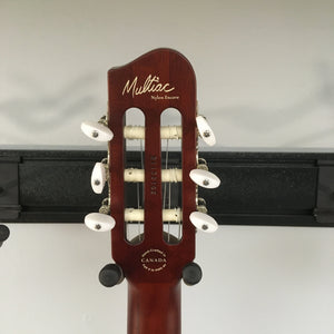 Close-up of a new Godin Multiac Nylon Encore SG SF guitar, highlighting its custom electronics and finish blemishes.