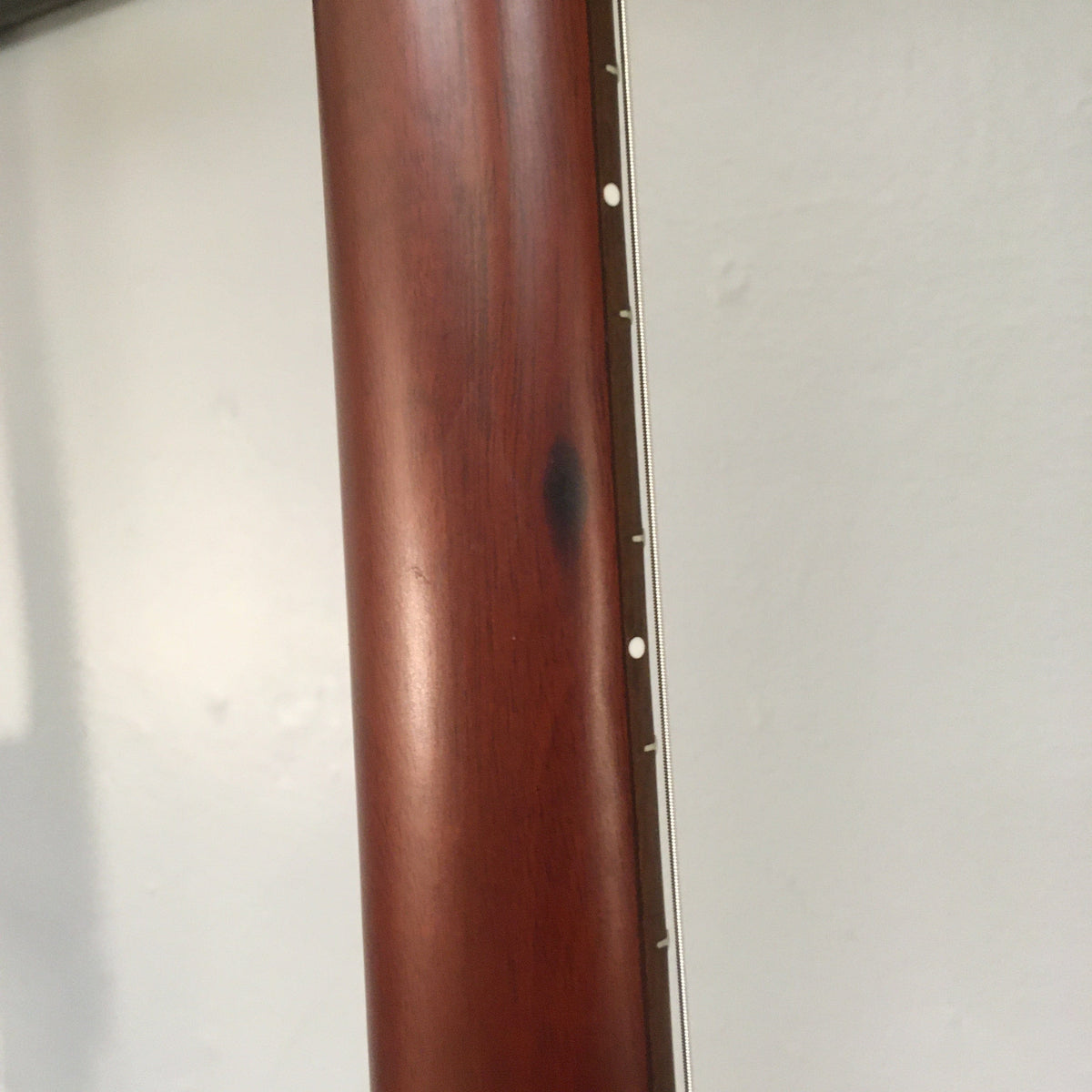 Godin Multiac Nylon Encore SG SF guitar with visible cosmetic blemishes, featuring a wooden body with several holes and a close-up of its wood surface.