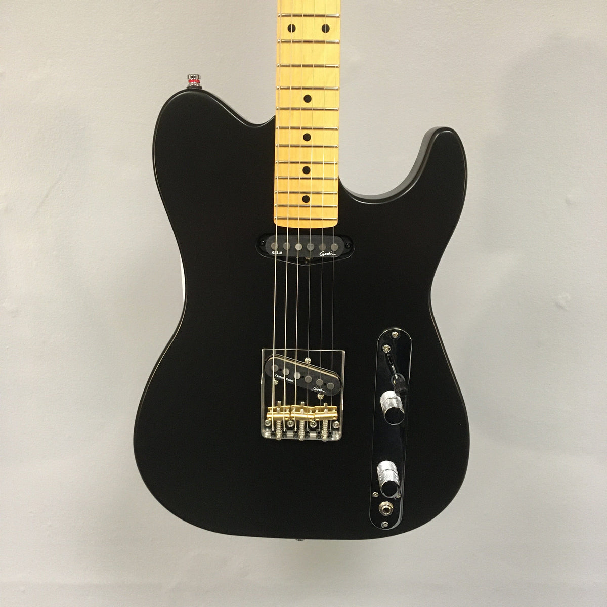 Godin Stadium HT Matte Black electric guitar with a yellow maple neck, showcasing its modern single-cut design and vintage-style control plate.