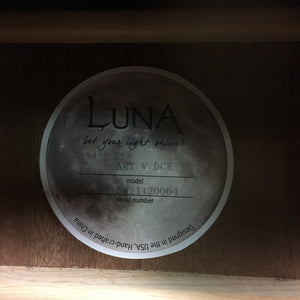 Luna Art Vintage Dreadnought Acoustic/Electric Guitar with a circular label featuring text and a moon on a wooden surface.