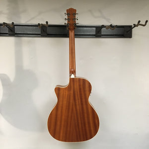Luna Art Vintage Grand Auditorium Solid Top Cutaway A/E guitar mounted on a wall, showcasing its mahogany body, spruce top, and brushed nickel open gear tuners.