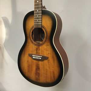 Luna Art Vintage Parlor Solid Top guitar with distressed vintage brownburst finish, featuring cream body binding and open gear tuners, hanging on a wall.