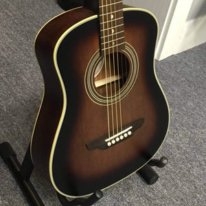 Luna Safari Artist Vintage Travel Guitar on stand, featuring mahogany body, spruce top, pearl moon phase inlays, and included gigbag.