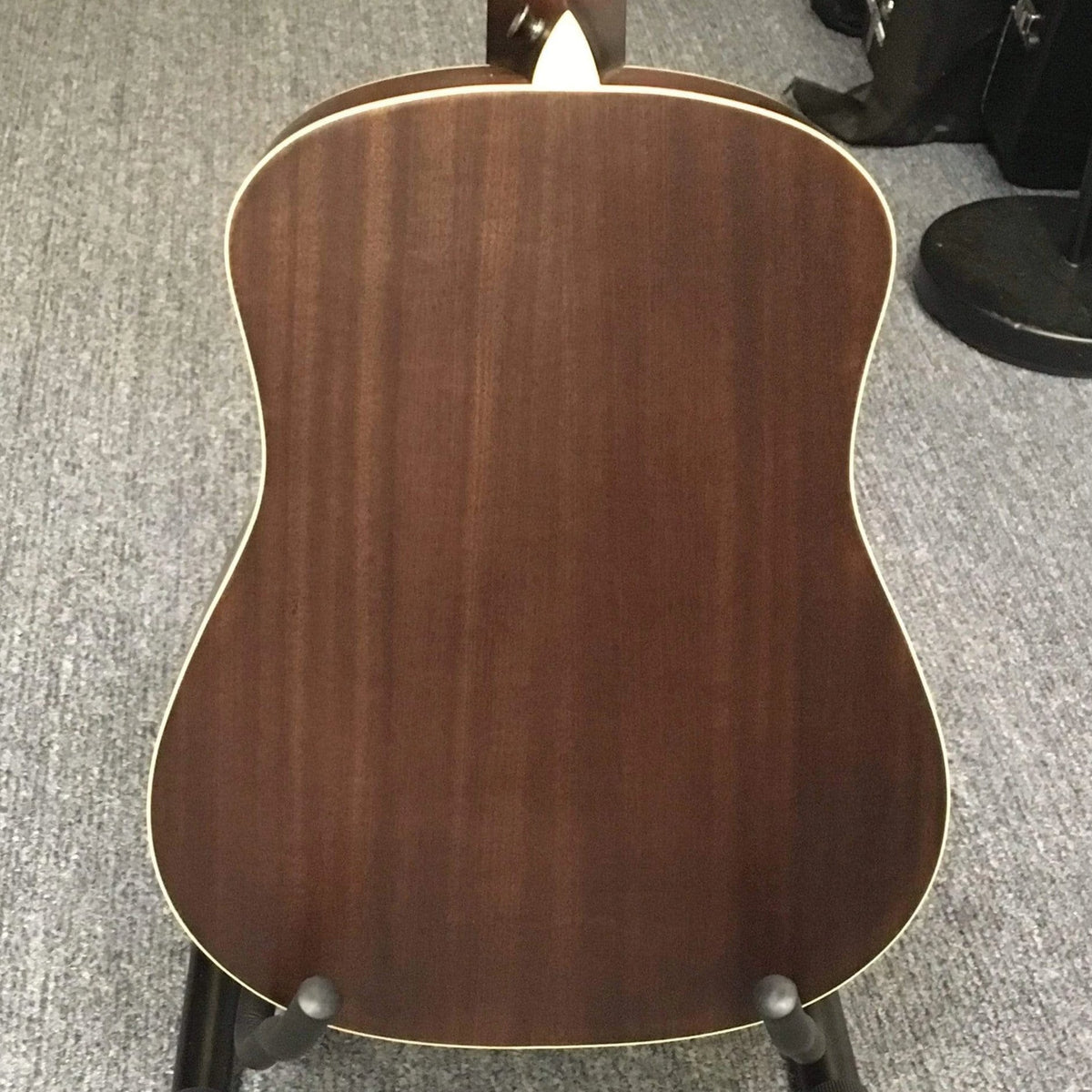 Luna Safari Artist Vintage Travel Guitar on a stand, featuring mahogany body, spruce top, and pearl moon phase inlays, with included branded gigbag.