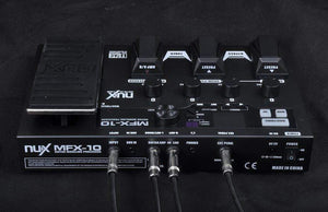 Nux MFX-10 Multi-Effects Processor, a black electronic device with wires, featuring various amp and pedal models, EQ controls, and a large backlit LCD screen.