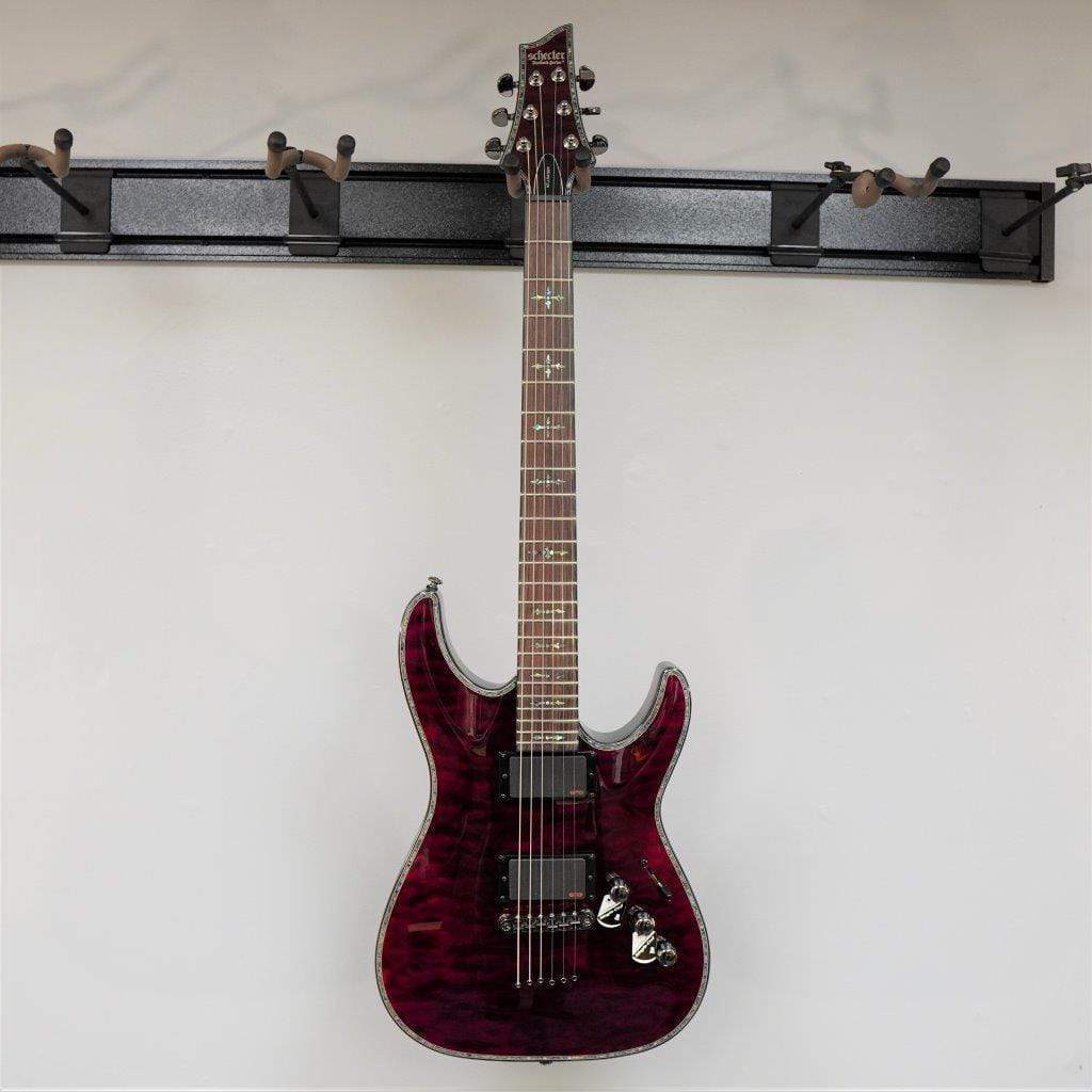 Schecter Hellraiser C-1 Black Cherry Electric Guitar mounted on a wall, showcasing its sleek design and high-quality construction.