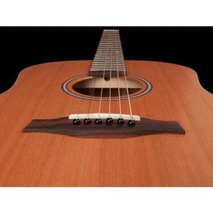 Close-up view of a Seagull S6 Original Left Handed Acoustic Guitar (Blemished) by Seagull, featuring a cedar top, six strings, the bridge, and sound hole, shot from the body toward the neck against a black background.