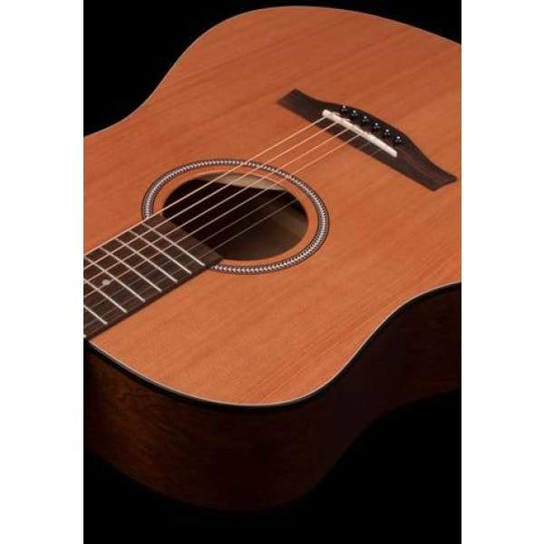 A close-up of the Seagull S6 Original Left Handed Acoustic Guitar (Blemished) by Seagull, highlighting its body, soundhole, bridge, and part of the fretboard against a black background.