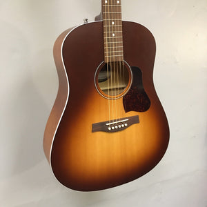 A Seagull Entourage Autumn Burst Acoustic Guitar by Seagull, featuring six strings, a glossy finish, round sound hole, and dark brown pickguard, is displayed hanging on a light gray wall.