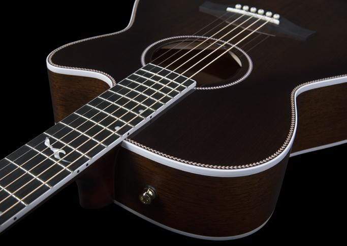 A close-up of the Seagull Artist Mosaic CH CW Acoustic-Electric Guitar - Bourbon Burst (with TRIC Case) displays its body, sound hole, and part of the fretboard with inlay designs against a black background, featuring striking white edge binding.