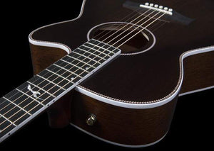 A close-up of the Seagull Artist Mosaic CH CW Acoustic-Electric Guitar - Bourbon Burst (with TRIC Case) displays its body, sound hole, and part of the fretboard with inlay designs against a black background, featuring striking white edge binding.