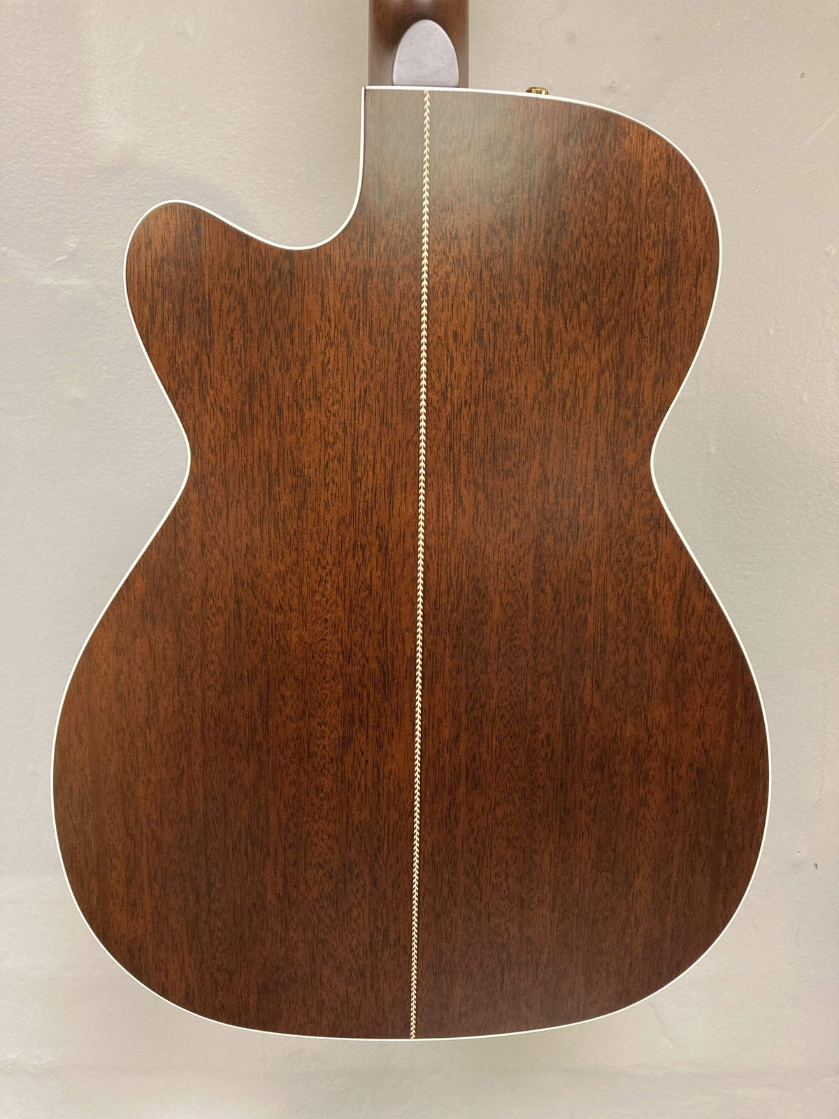 The image shows the back of a Seagull Artist Mosaic CH CW Acoustic-Electric Guitar - Bourbon Burst by Seagull, featuring a dark wood finish, white center inlay, and white binding, set against a plain light-colored wall.