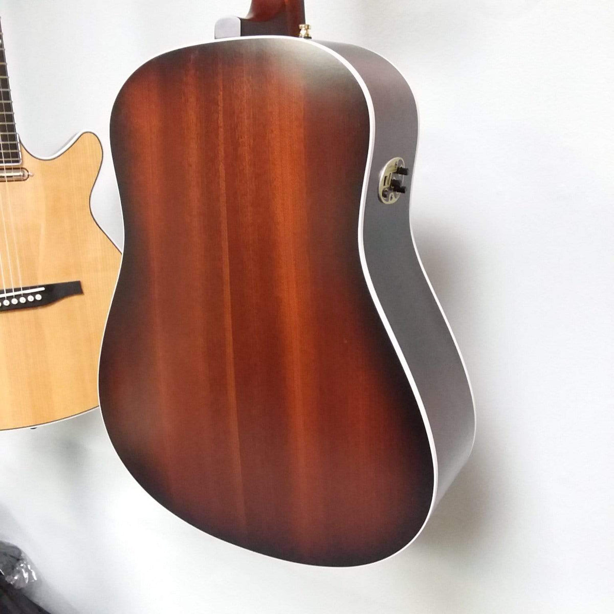 Seagull Maritime SWS Mahogany Burnt Umber GT QIT Acoustic Guitar mounted on a wall, highlighting its solid wood construction and elegant finish.