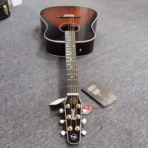Seagull Maritime SWS Mahogany Burnt Umber GT QIT Acoustic Guitar lying on a grey surface, showcasing its elegant design and quality craftsmanship.