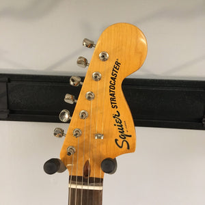 Squier Classic Vibe '70s Stratocaster Black Refurb, close-up of guitar body and strings, showing finish flaw and vintage-style tremolo system.