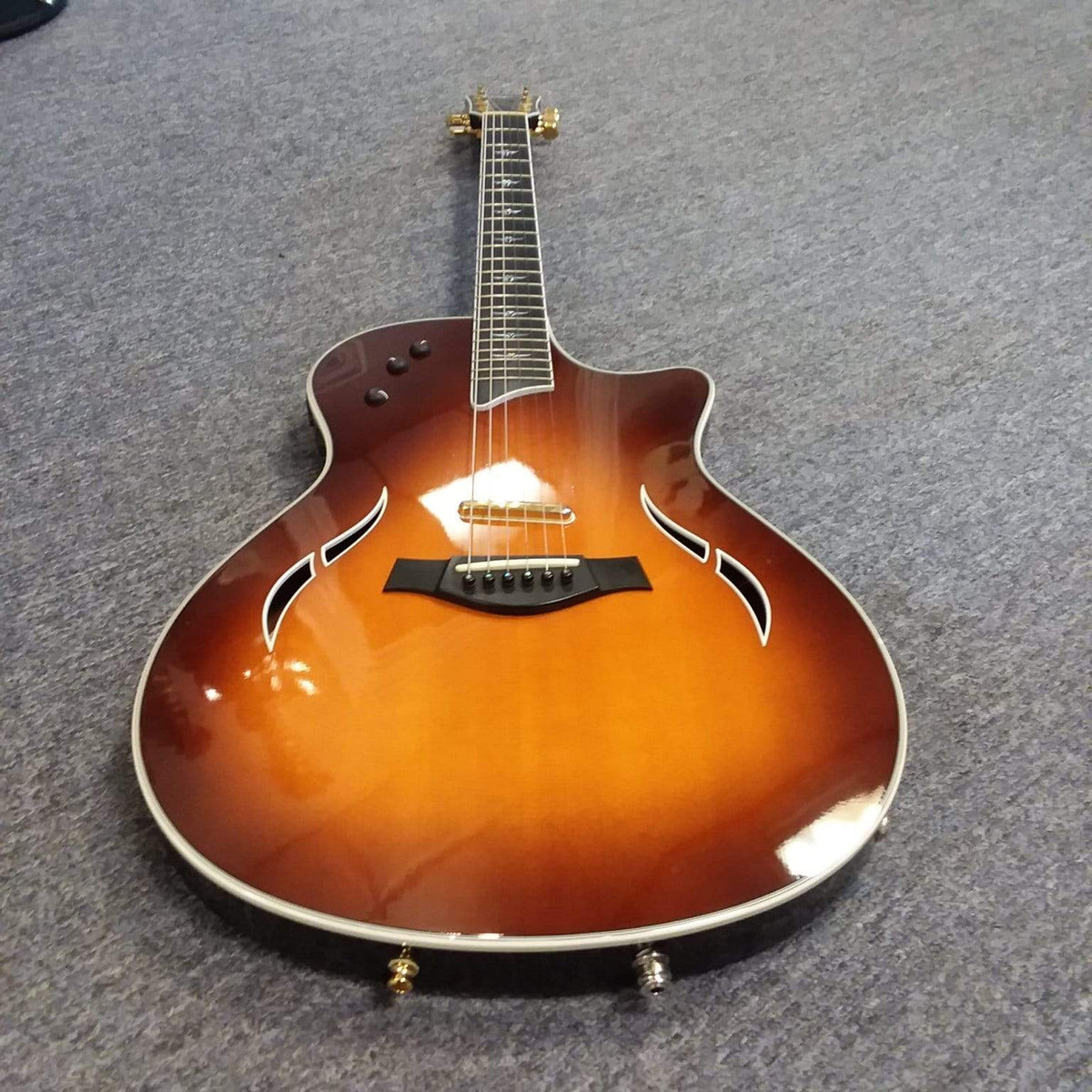 Taylor T5-C 2006 guitar with Custom Fishman Matrix Piezo, shown on grey carpet, highlighting its strings and body details.